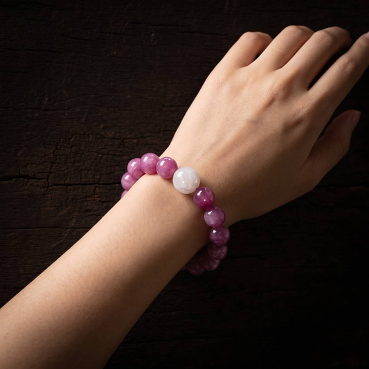 Purple 10mm round-bead bracelet with one pale bead worn on a wrist