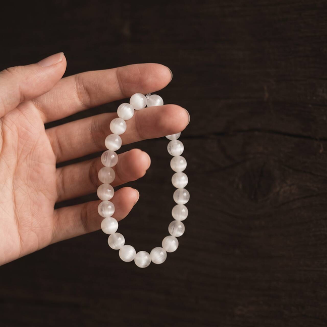 White Rutilated Quartz bracelet held in hand in natural light