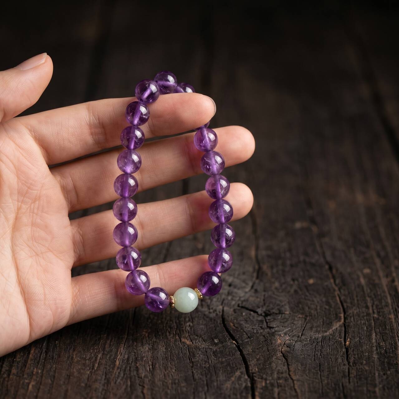Amethyst bracelet with 10mm beads shown in hand under natural light