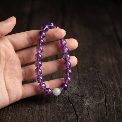 Amethyst bracelet with 10mm beads shown in hand under natural light