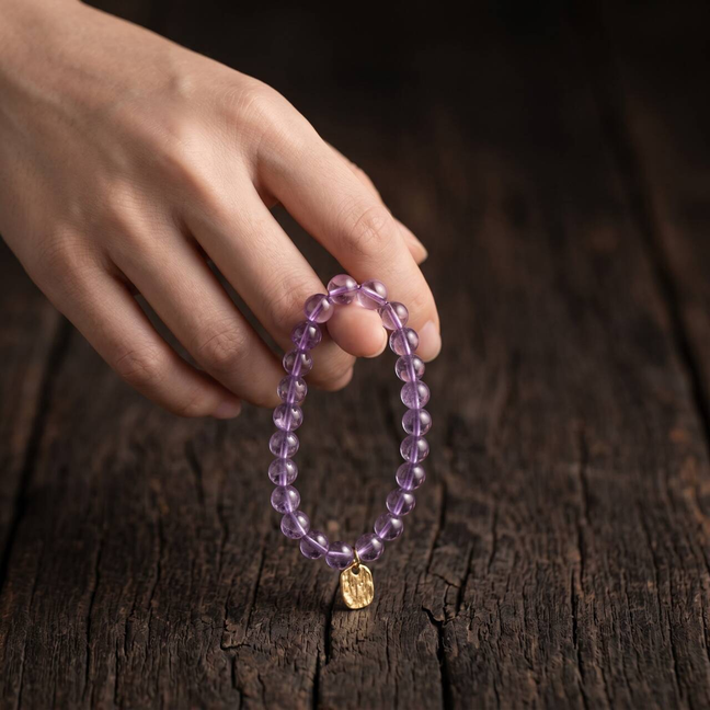 6mm amethyst bracelet held in hand in natural light