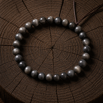Natural black gold sunstone bracelet in 7MM beads on a dark brown wood background