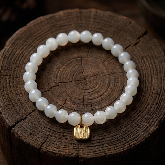 Natural 7mm Hetian jade bracelet in creamy white displayed on dark wood
