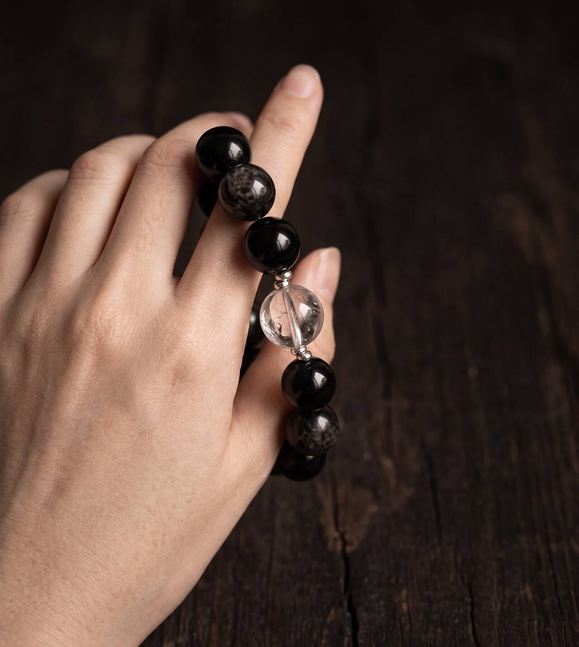Obsidian bracelet with 10mm beads shown in hand under natural light